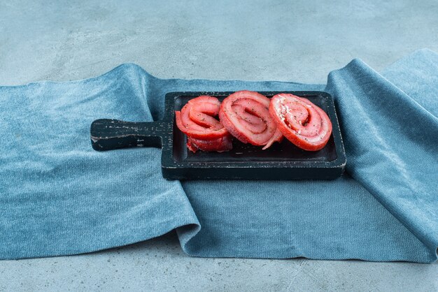 Pork lard on a board on pieces of fabric , on the blue table. 