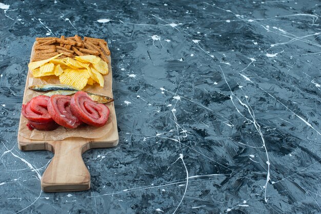 Free photo pork lard, fish, chips and breadcrumbs on a cutting board , on the blue background.