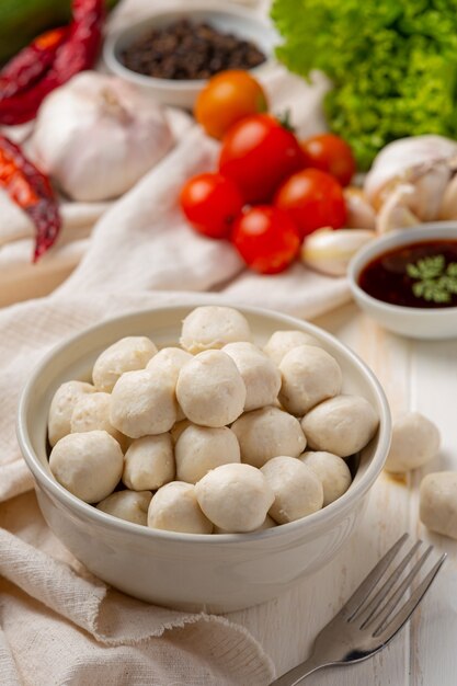 Pork meatballs on the white wooden surface.