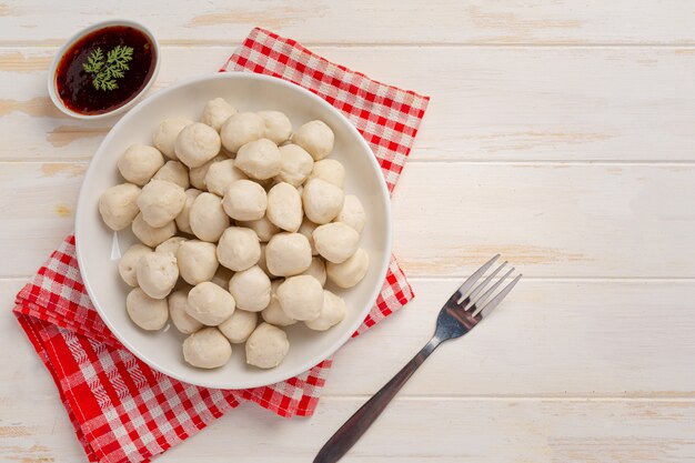 Pork meatballs on the white wooden surface.