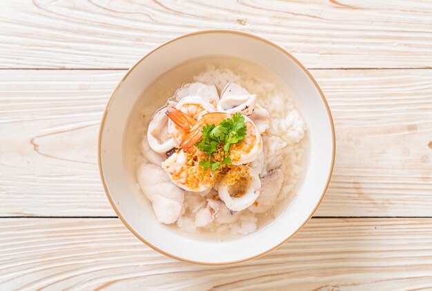 お粥またはご飯とシーフード（エビ、イカ、魚）ボウル Premium写真