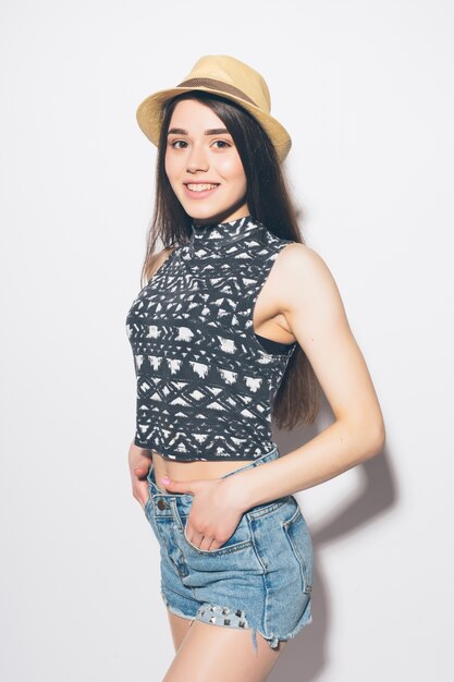 Porrtrait of a smiling playful shy woman wearing summer clothes isolated over gray wall