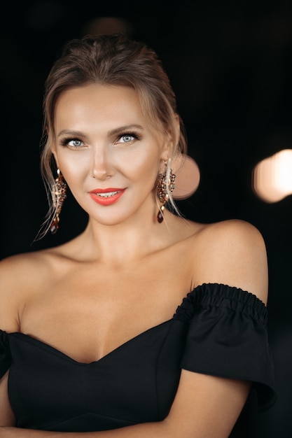 Portait of charming caucasian lady poses for the camera, picture isolated on dark blur background