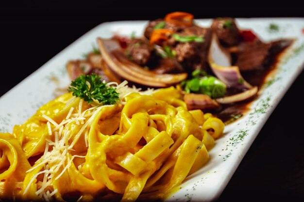 Portion of delicious pasta with cheese sauce and fried meat