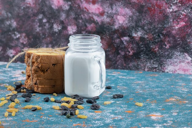 A portion of pie served with a jar of milk.