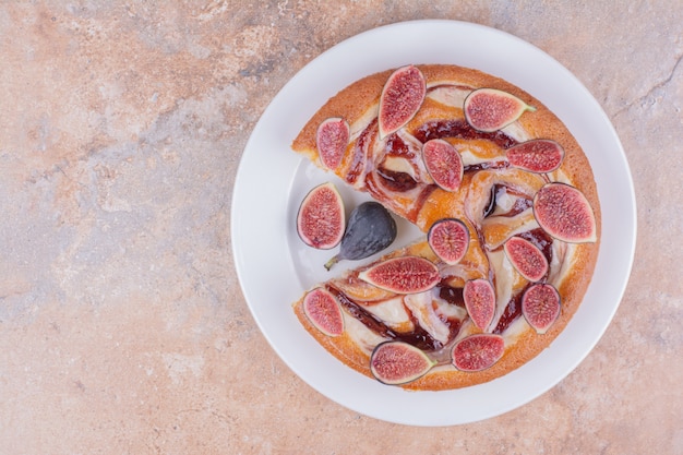 A portion of pie with purple figs in a white plate