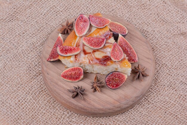 A portion of pie with purple figs in a wooden platter