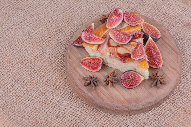 A portion of pie with purple figs in a wooden platter