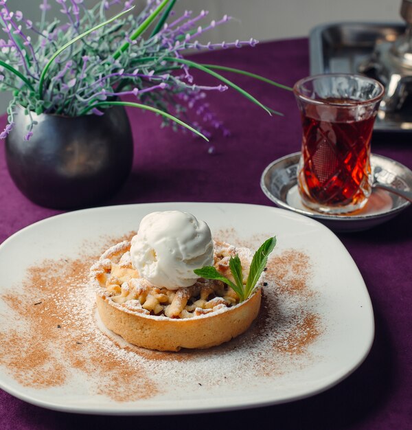 portioned apple tarte with vanilla ice cream, on purple tablecloth