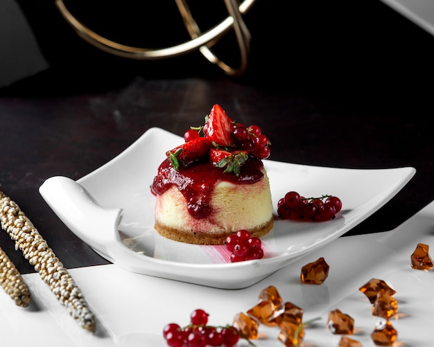 Portioned cheesecake topped with berries and jam