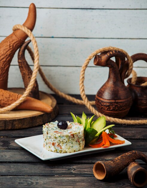 Portioned olivier salad garnished with cucumber and carrot flowers