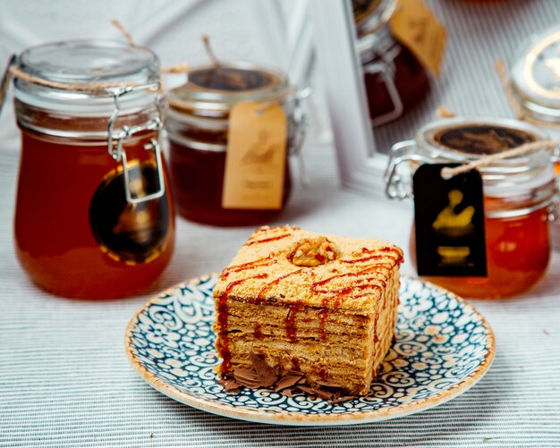 Portioned square honey cake garnished with syrup and walnut