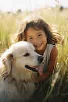 Free photo portrait of adorable child with their dog on the field