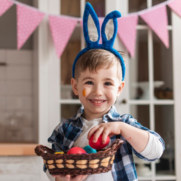 Portrait of adorable little boy holding basket with eggs