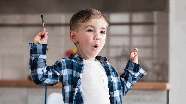 Foto gratuita ritratto del pennello adorabile della tenuta del piccolo bambino