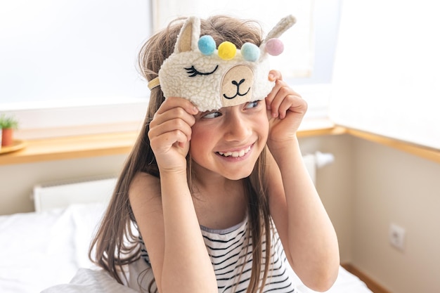 Portrait of adorable little girl walked up in her bed in the sunny morning