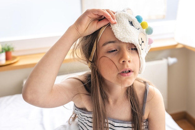 Portrait of adorable little girl walked up in her bed in the sunny morning