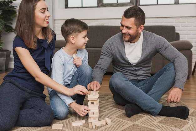 Foto gratuita ritratto dei genitori adorabili che giocano con il figlio