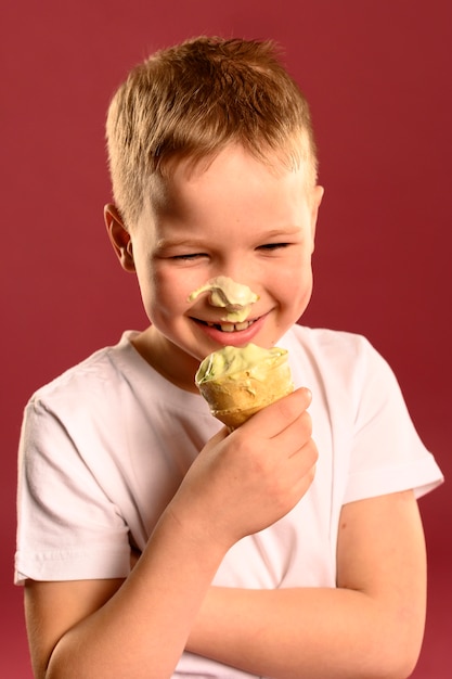 Портрет очаровательны мальчика едят мороженое