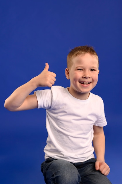 Portrait of adorable young boy with thumb up