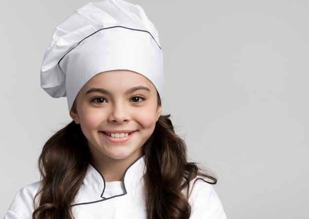 Foto gratuita ritratto di adorabile giovane chef sorridente