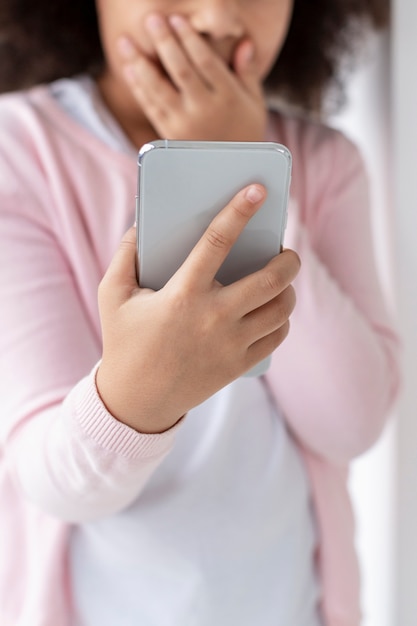 Free photo portrait of adorable young girl holding mobile phone