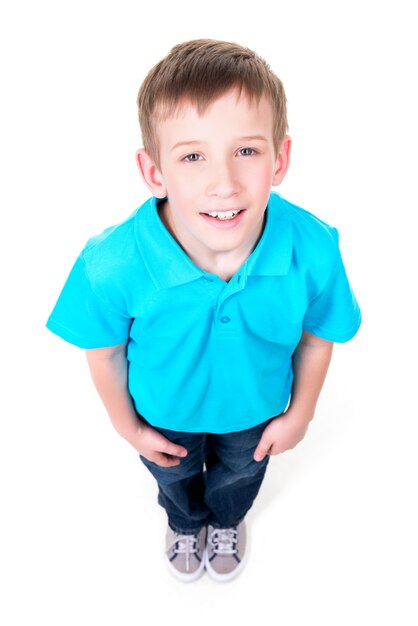 青いTシャツで見上げる愛らしい若い幸せな少年の肖像画。上面図。白い背景で隔離。