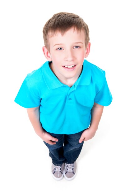 Portrait of adorable young happy boy looking up in blue t-shirt. Top view. Isolated on white background.