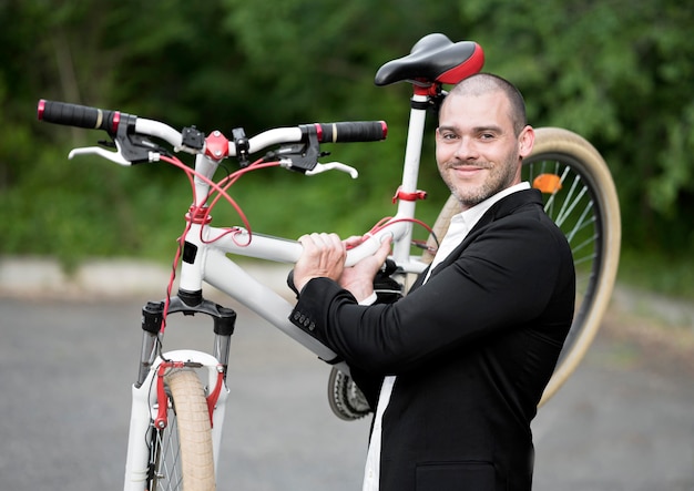 Free photo portrait of adult male carrying bicycle