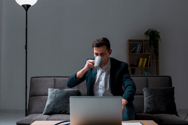 Portrait of adult male enjoying coffee while working at night