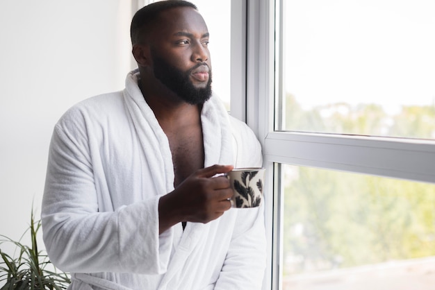 Foto gratuita ritratto del maschio adulto che gode della tazza di caffè