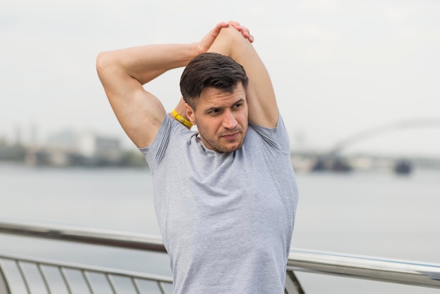 Portrait of adult male stretching outdoors