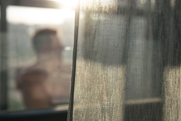 カーテンと窓からの影を持つ成人男性の肖像画