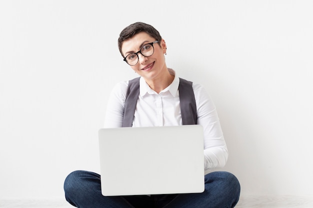 Portrait of adult woman holding laptop