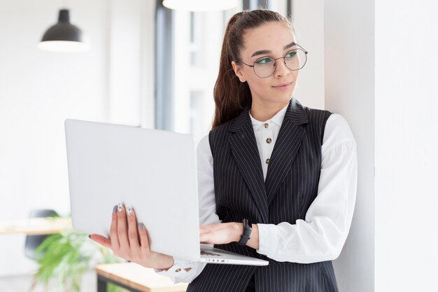 Portrait of adult woman holding laptop