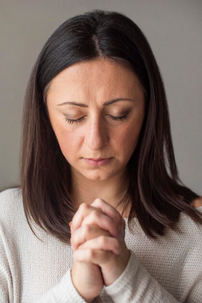 Portrait of adult woman praying at home