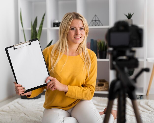 Portrait of adult woman recording video at home