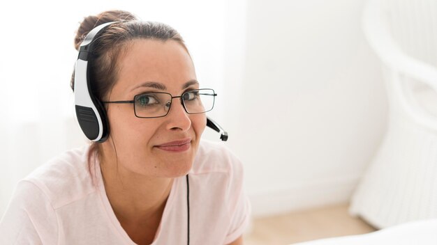 Portrait of adult woman working with headphones on