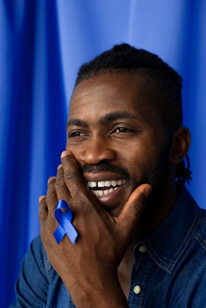 Free photo portrait of african american man with blue ribbon