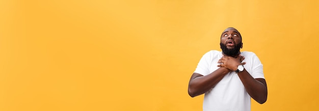Foto gratuita ritratto di uomo afroamericano con le mani sollevate in stato di shock e incredulità isolate su sfondo giallo