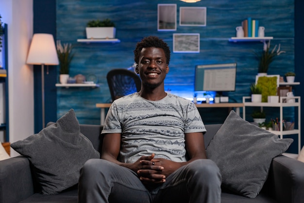 Portrait of african american young employee sitting on sofa