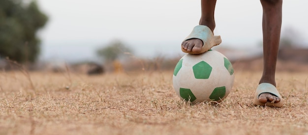 サッカーボールの肖像画アフリカの子をクローズアップ