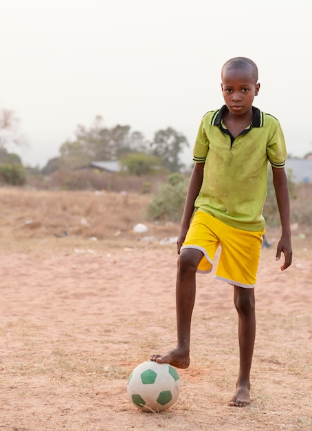 Foto gratuita ritratto di bambino africano con pallone da calcio