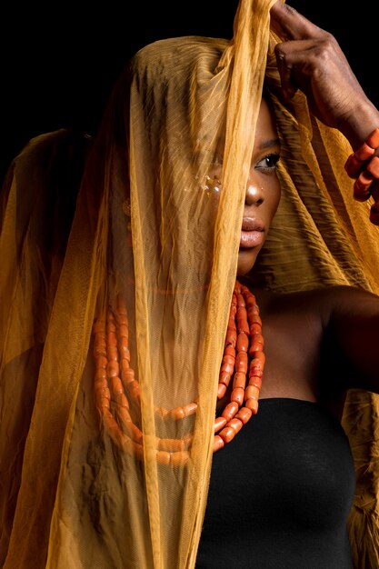 Portrait of african woman wearing traditional accessories and yellow veil