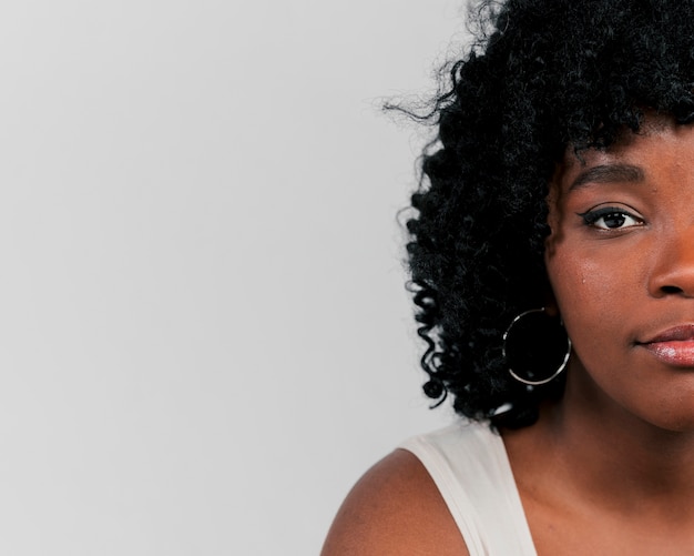 Portrait of an african young woman looking at camera against grey background