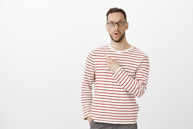 Portrait of amazed impressed handsome man with bristle in black glasses