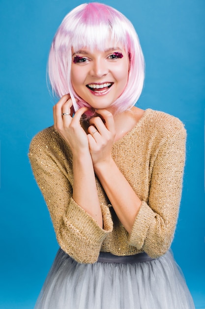 Free photo portrait amazing young woman with pink haircut . brightful makeup with pink tinsels, tulle skirt,  expressing true positive emotions, magic time, party, celebration.