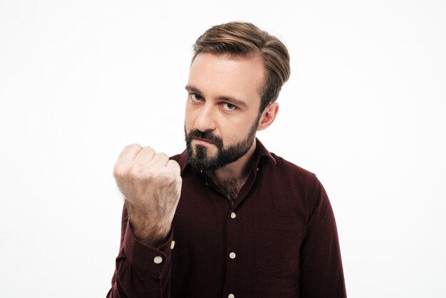 Portrait of an angry furious man threatening with a fist