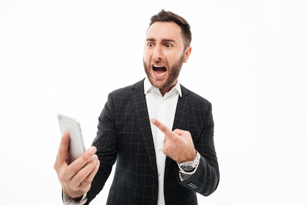 Portrait of an angry man holding mobile phone