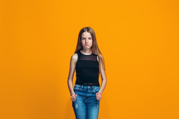 Portrait of angry teen girl on a orange